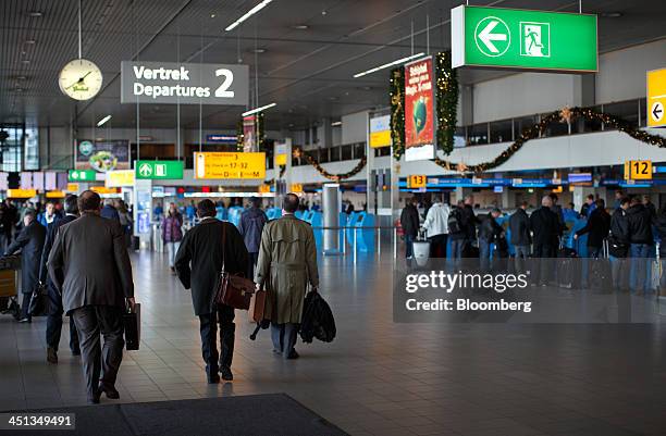 Travelers pass through the departure lounge at Schiphol Airport, operated by the Schiphol Group, in Amsterdam, Netherlands, on Thursday, Nov. 21,...