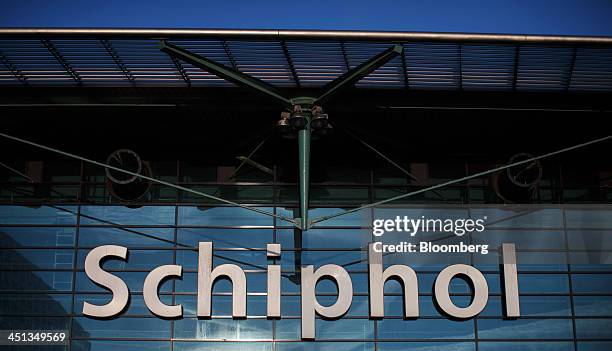 Sign sits on the glass facade of Schiphol Airport, operated by the Schiphol Group, in Amsterdam, Netherlands, on Thursday, Nov. 21, 2013. The...