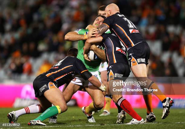 David Shillington of the Raiders is tackled by the Tigers defence during the round 16 NRL match between the Wests Tigers and the Canberra Raiders at...