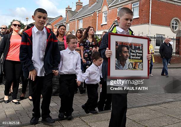 -- Please Note - additional information added to caption -- Padraig McKernan , aged 10, great nephew of Gerry Conlon, carries a framed newspaper...