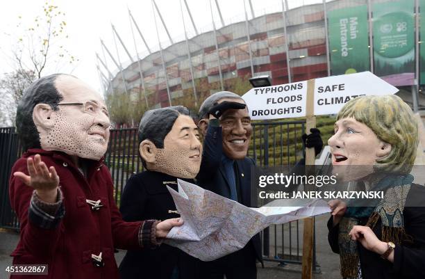 Activists wearing masks featuring France's President Francois Hollande, Japanese Prime Minister Shinzo Abe,United States President Barack Obama and...