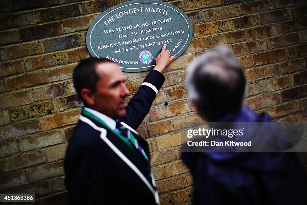 Wimbledon official points out the plague that is on the outside of Court 18 to commemorate the longest match which was between John Isner and Nicolas...