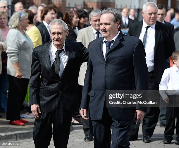 The coffin of Gerry Conlon is carried into St. Peter's Cathedral for a requiem mass watched by fellow Guildford Four members Paddy Armstrong and...