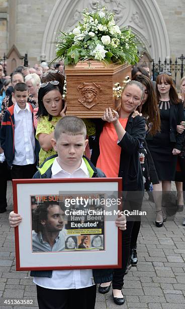 The coffin of Gerry Conlon is carried from St. Peter's Cathedral after a requiem mass by family members as 10 year old Padraig McKernan holds a...
