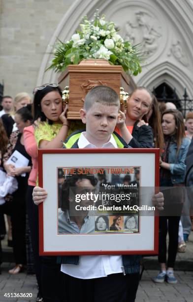 The coffin of Gerry Conlon is carried from St. Peter's Cathedral after a requiem mass by family members as 10 year old Padraig McKernan holds a...