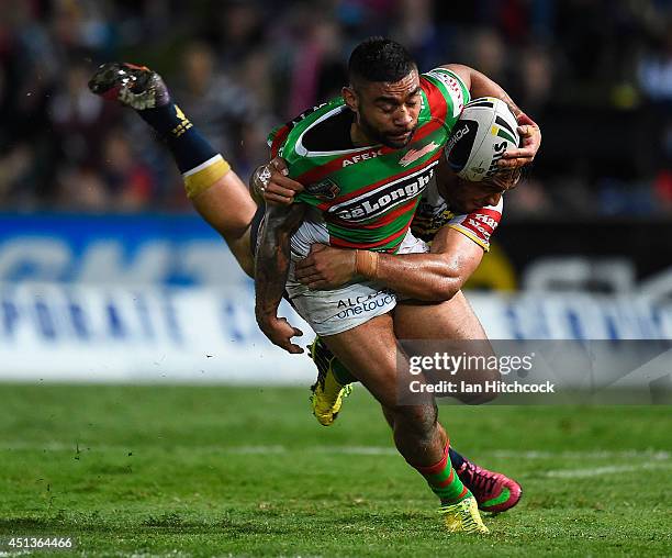 Nathan Merritt of the Rabbitohs is tackled by Curtis Rona of the Cowboys during the round 16 NRL match between the North Queensland Cowboys and the...