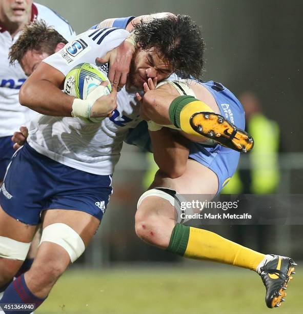 Steven Luatua of the Blues is tackled by Hugh McMeniman of the Force during the round 17 Super Rugby match between the Force and the Blues at nib...