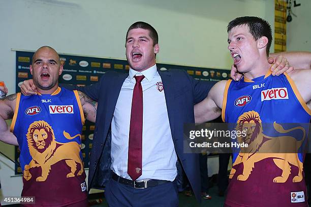 Ashley McGrath, Jonathan Brown and Justin Clarke of the Lions sing the team song after winning the round 15 AFL match between the Brisbane Lions and...