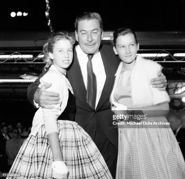 Actor Errol Flynn poses with daughters Deidre 12 and Rory 10 at the premier of "My Man Godfrey: in Los Angeles, California.