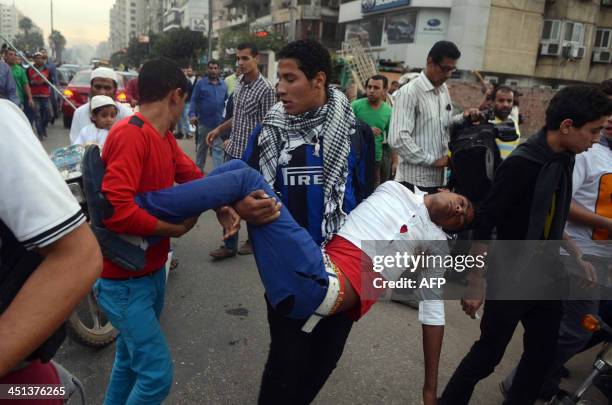 Supporters of ousted president Mohamed Morsi and the Muslim brotherhood carry an injured comrade during clashes with Egyptian riot police close to...