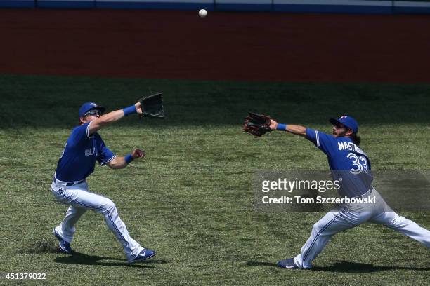 Colby Rasmus of the Toronto Blue Jays catches a fly ball while nearly colliding with Darin Mastroianni in the first inning during MLB game action...