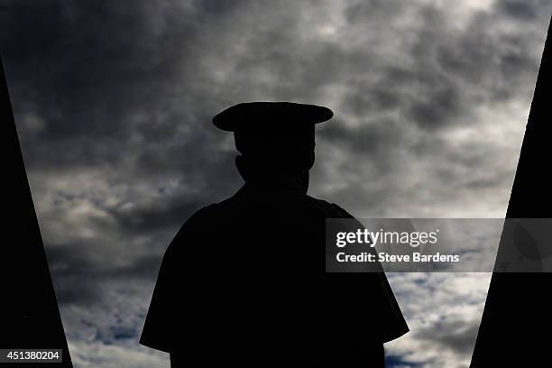 Silhouette of a security guard at an entrance to a court on day six of the Wimbledon Lawn Tennis Championships at the All England Lawn Tennis and...