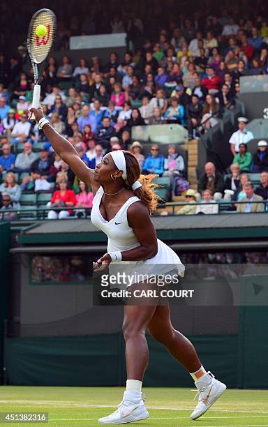 Player Serena Williams serves to France's Alize Cornet during their women's singles third round match on day six of the 2014 Wimbledon Championships...
