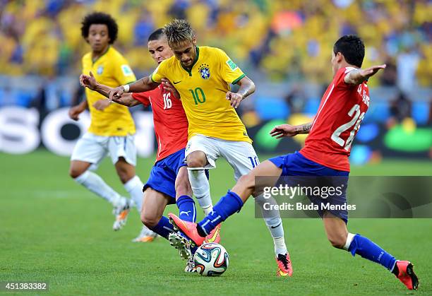 Neymar of Brazil is challenged by Felipe Gutierrez and Charles Aranguiz of Chile during the 2014 FIFA World Cup Brazil round of 16 match between...