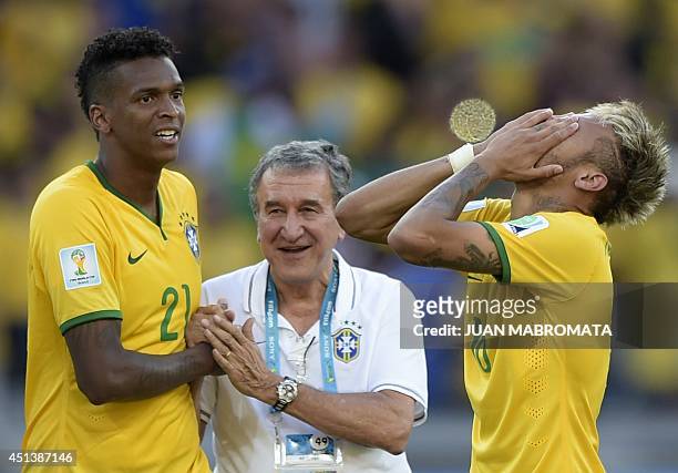 Brazil's forward Jo and Brazil's forward Neymar celebrate with a member of the coaching team after Brazil won their match against Chile in a penalty...