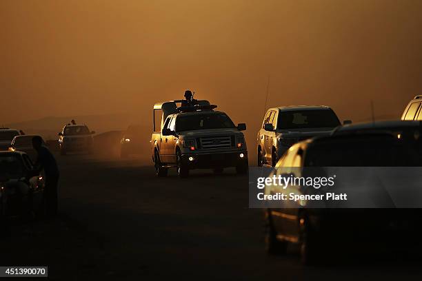 Members of the Peshmerga drive down a street outside of a displacement camp for those caught-up in the fighting in and around the city of Mosul on...