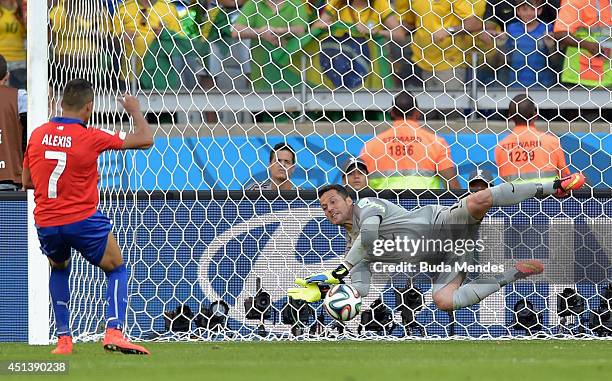 Julio Cesar of Brazil saves the penalty shot of Alexis Sanchez of Chile in a shootout during the 2014 FIFA World Cup Brazil round of 16 match between...