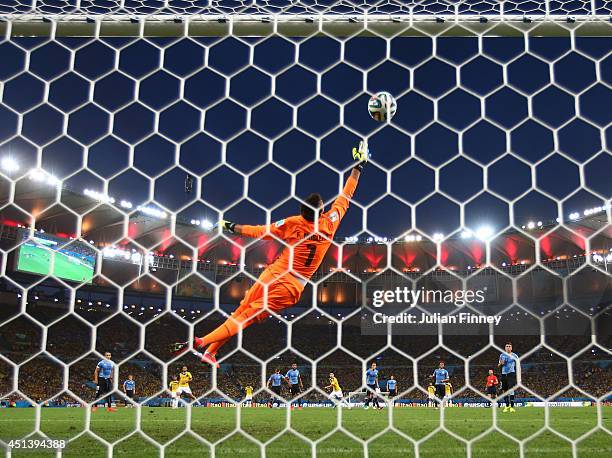 James Rodriguez of Colombia scores his team's first goal past Fernando Muslera of Uruguay during the 2014 FIFA World Cup Brazil round of 16 match...