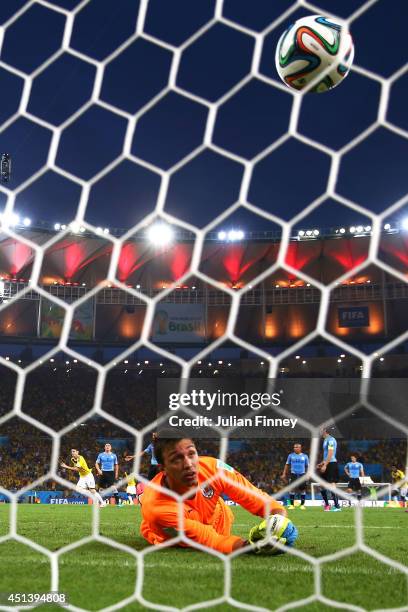 James Rodriguez of Colombia scores his team's first goal past Fernando Muslera of Uruguay during the 2014 FIFA World Cup Brazil round of 16 match...