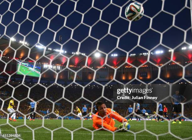 James Rodriguez of Colombia scores his team's first goal past Fernando Muslera of Uruguay during the 2014 FIFA World Cup Brazil round of 16 match...