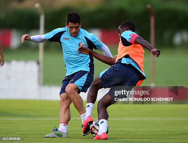 Costa Rica's defender Johnny Acosta vies for the ball with Costa Rica's forward Joel Campbell during a training session at the Wilson Campos training...