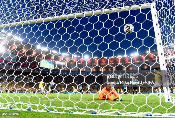 James Rodriguez of Colombia scores his team's first goal past Fernando Muslera of Uruguay during the 2014 FIFA World Cup Brazil Round of 16 match...