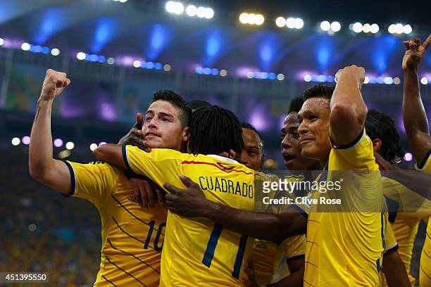 James Rodriguez of Colombia celebrates scoring his team's second goal and his second of the game with teammates during the 2014 FIFA World Cup Brazil...