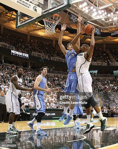 Adreian Payne of the Michigan State Spartans drives the ball to the basket as Luke McComber of the Columbia Lions during the second half of the game...