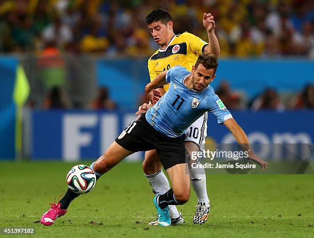 James Rodriguez of Colombia challenges Christian Stuani of Uruguay during the 2014 FIFA World Cup Brazil round of 16 match between Colombia and...