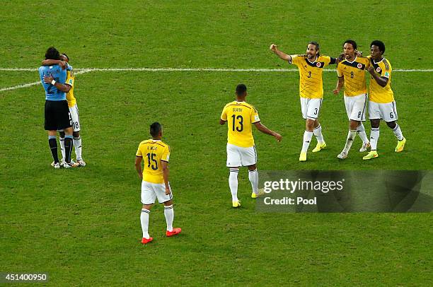 Juan Camilo Zuniga of Colombia hugs Edinson Cavani of Uruguay as teammates Alexander Mejia, Fredy Guarin, Mario Yepes, Abel Aguilar and Carlos...