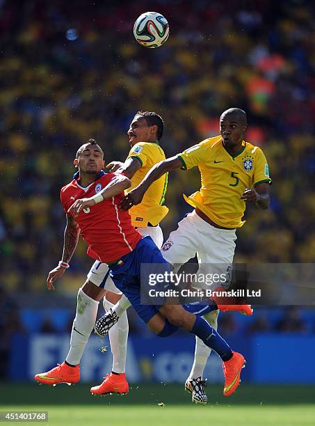 Luis Gustavo and Fernandinho of Brazil jump for a header with Arturo Vidal of Chile during the 2014 FIFA World Cup Brazil Round of 16 match between...
