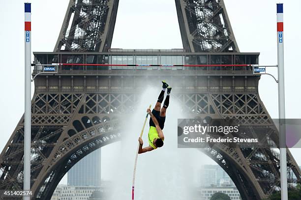 Valentin Lavillenie, brother of Renaud Lavillenie, performs a pole vault in front of the Eiffel tower on June 28, 2014 in Paris, France.