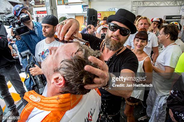 Hairdresser Michael Jung washes the hair of the german actor Gerrit Grass with beer during the 8th Ischgl Cart Trophy on June 28, 2014 in Ischgl,...