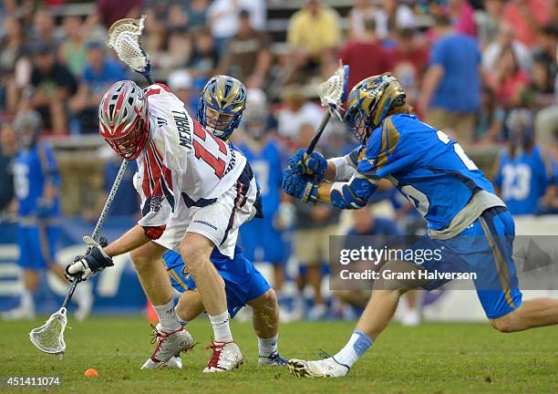 Mike Chanenchuk and John Haus of the Charlotte Hounds battle for a ground ball with Brodie Merrill of the Boston Cannons during their game at...