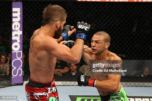 Cub Swanson punches Jeremy Stephens in their featherweight bout at the AT&T Center on June 28, 2014 in San Antonio, Texas.