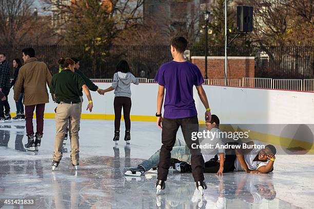 Two boys fall on the ice while ice skating at the ice rink at McCarren Pool, which opened for the winter months last week, on November 22, 2013 in...