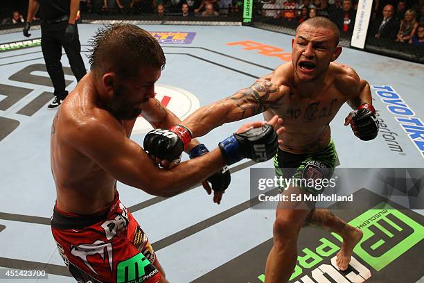 Cub Swanson punches Jeremy Stephens in their featherweight bout at the AT&T Center on June 28, 2014 in San Antonio, Texas.