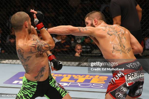 Jeremy Stephens punches Cub Swanson in their featherweight bout at the AT&T Center on June 28, 2014 in San Antonio, Texas.