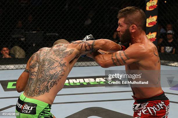 Cub Swanson punches Jeremy Stephens in their featherweight bout at the AT&T Center on June 28, 2014 in San Antonio, Texas.