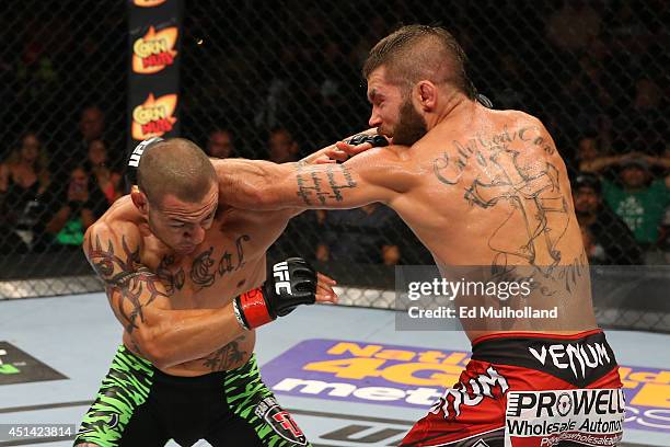 Cub Swanson punches Jeremy Stephens in their featherweight bout at the AT&T Center on June 28, 2014 in San Antonio, Texas.