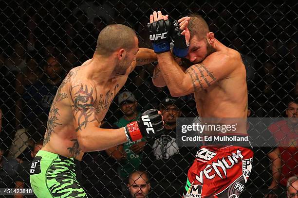 Cub Swanson punches Jeremy Stephens in their featherweight bout at the AT&T Center on June 28, 2014 in San Antonio, Texas.