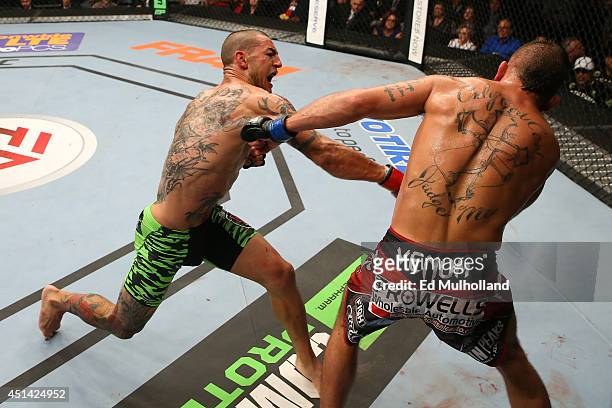 Cub Swanson punches Jeremy Stephens in their featherweight bout at the AT&T Center on June 28, 2014 in San Antonio, Texas.