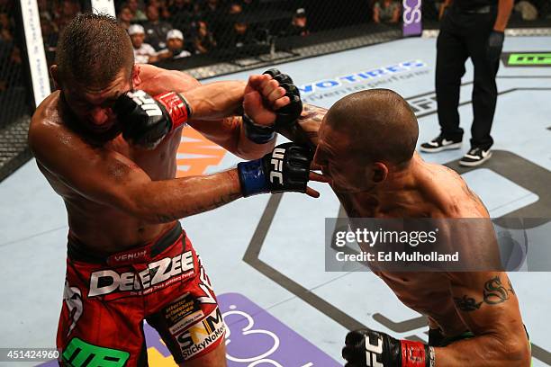 Cub Swanson punches Jeremy Stephens in their featherweight bout at the AT&T Center on June 28, 2014 in San Antonio, Texas.