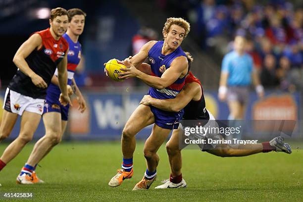 Mitch Wallis of the Bulldogs is tackled during the round 15 AFL match between the Western Bulldogs and the Melbourne Demons at Etihad Stadium on June...