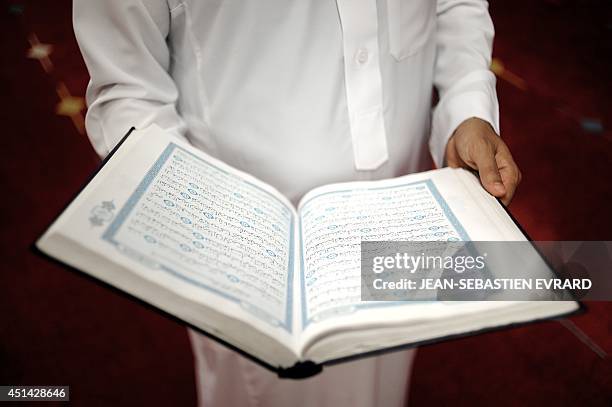 Belgacem Bensaid, Imam of the Assalam Mosque, shows the Quran after a prayer at Assalam Mosque on June 28, 2014 in Nantes, western France, on the eve...