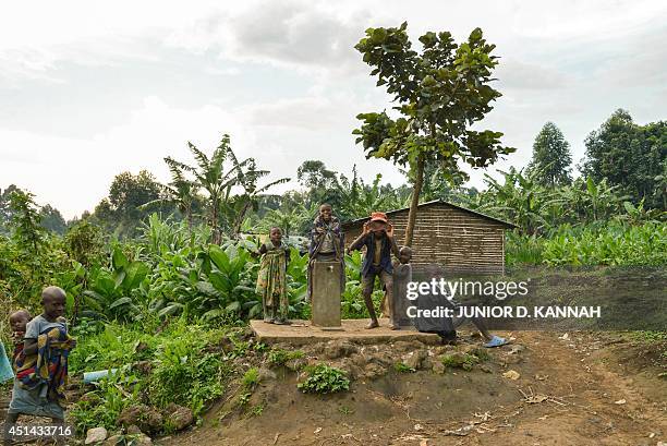 Children from the villagers of Gisigari and Rugari, some 50 kms north of Goma in the Virunga National Park, play by a dried well on June 17, 2014....