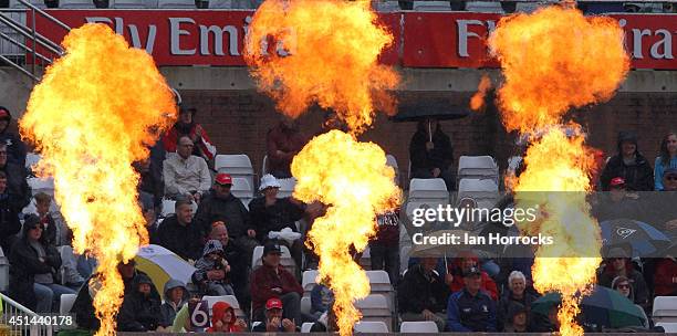 Flame throwers go off in front of fans sitting under their umbrellas as it rains during The Natwest T20 Blast match between Durham Jets and...