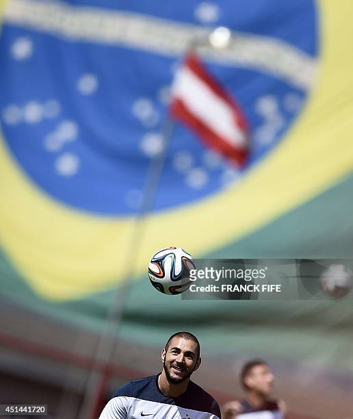 France's forward Karim Benzema heads a ball during a training session in Brasilia on June 29 on the eve of their FIFA 2014 World Cup Round of 16...