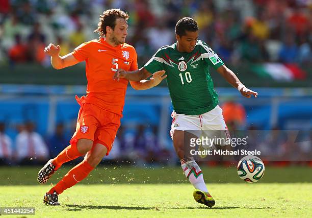 Giovani dos Santos of Mexico shoots and scores his team's first goal against Daley Blind of the Netherlands during the 2014 FIFA World Cup Brazil...