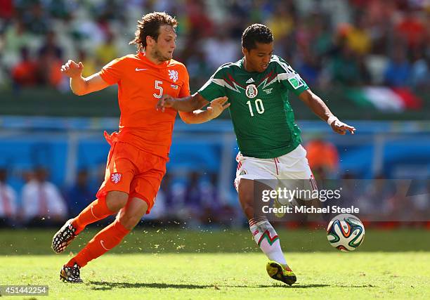 Giovani dos Santos of Mexico shoots and scores his team's first goal against Daley Blind of the Netherlands during the 2014 FIFA World Cup Brazil...